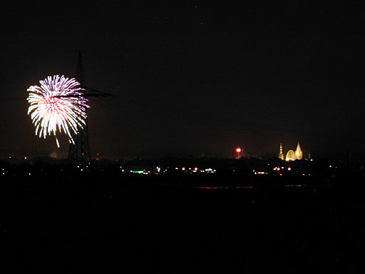 links hinterÂ´m Hochspannungsmast das Feuerwerk - recht Powertower und Riesenrad zwischen Kirchtürmen